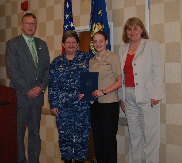 Teresa Duvall (r), chapter president, presents the April Military Cyber Professional of the Month Award to Petty Officer Third Class Lauren Mclelland, USN, Naval Computer Telecommunications Area Master Station, Atlantic (NCTAMS LANT). Capt. Danelle Barrett, USN, commanding officer, NCTAMS LANT, and Doug Vanderlip, chapter executive vice president, stand witness.
